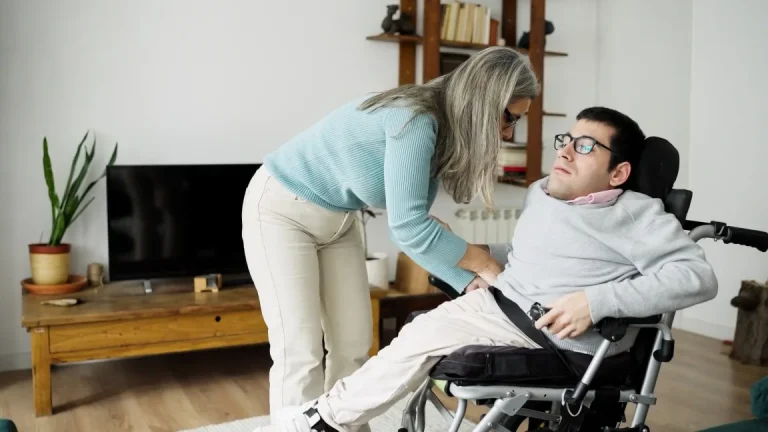 Support worker helping disabled man in wheelchair