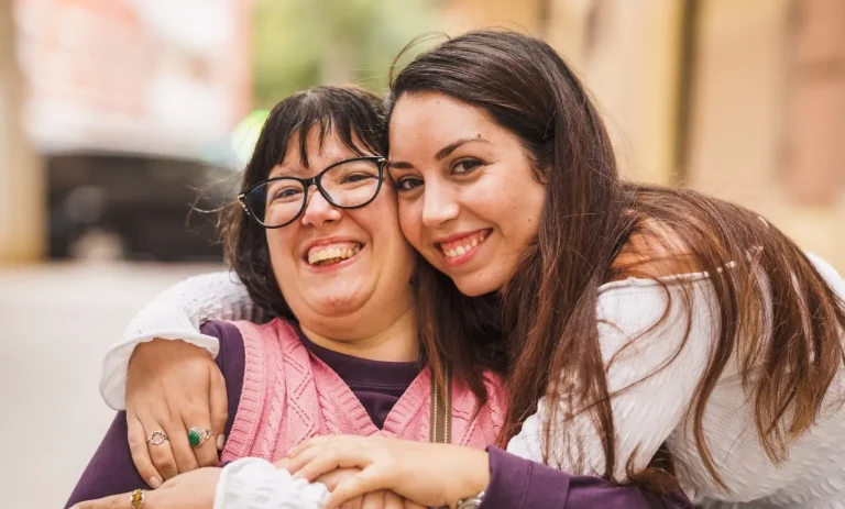 Support worker hugging woman in wheelchair